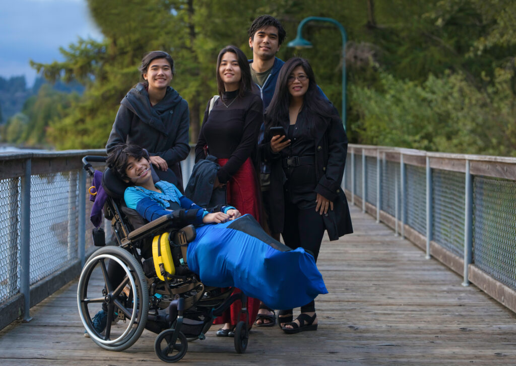 A family standing around their loved one in a wheelchair